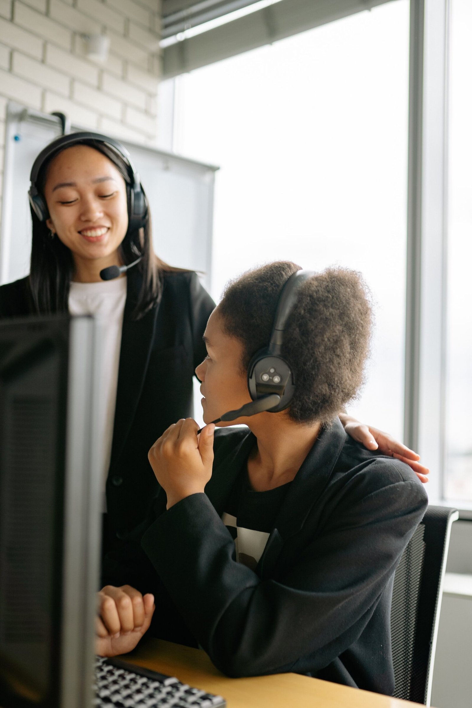 Two call center agents communicating in an office setting, enhancing teamwork.